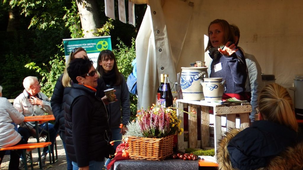 Stand mit Steinkrügen und Herbstdekoration