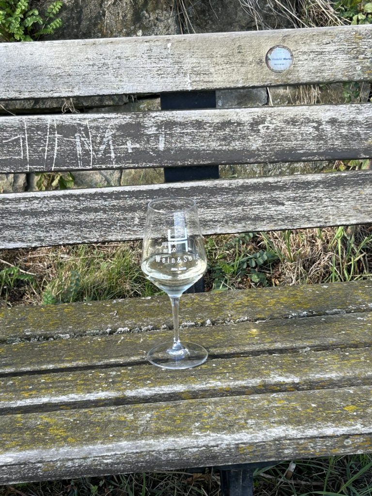 Weinglas auf einer Holzbank im Weinberg